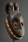 Guro Hörnermaske, Elfenbeinküste, ovale Form mit farblich abgesetztem Zackenrelief und zwei Hörnern