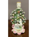 An 18th century Derby candlestick figure group of two rabbits feeding from a foliated hedge front,