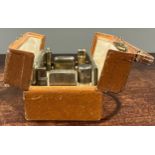 A George V silver travelling set, the leather case with hinged twin-covers, enclosing a mirror,
