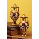 A pair of Royal Crown Derby 1128 Imari pattern two handled pedestal vases and covers, solid gold