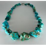 A silver mounted turquoise necklace, formed of twenty eight graduated pebbles, 55cm long