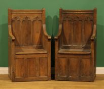 A pair of Gothic Revival design oak panel back box seat armchairs, the architectural back carved