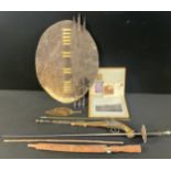 An African hide oval shield, knife, spear tip, Indonesian short sword or knife with carved wooden