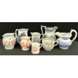 A pearlware jug, moulded in relief with grinning Bacchic masks, on a ground of coloured dabs and