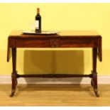 A post-Regency rosewood sofa table, rounded rectangular top with fall leaves above a pair of