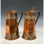 Keswick School of Industrial Art - a pair of Arts and Crafts copper water jugs, hinged domed