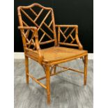 A Chippendale style faux bamboo armchair, lattice-work back and sides, pagoda-style top rail,