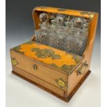 A Victorian three-bottle oak tantalus and games compendium cabinet, the mirrored gallery top housing