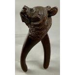 A Black Forest novelty lever-action nut cracker, carved as the head of a bear, glass eyes, 20.5cm