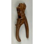 A Black Forest novelty lever-action nut cracker, carved with a smiling gnome, full-length, 28cm