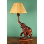 An Anglo-Indian hardwood table lamp, carved as an elephant, ivorine tusks, 62.5cm high under