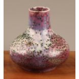 A Ruskin Pottery crystalline glaze bottle vase, glazed in deep purple tones and mottled crimson,