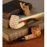 A 19th century Meerschaum pipe, the bowl carved with the head of a Russian man, leather case; others