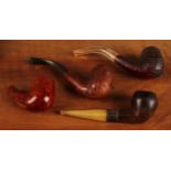 A briar wood pipe, the bowl carved with floral motifs, 14cm long overall; others similar (4)