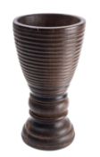 A turned lignum vitae mortar, 19th century; the tapered body with ribbed exterior,