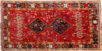 A Qashgai carpet, of small size, the red field with twin shaded hooked lozenge medallions,