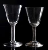Two English wine glasses with rounded funnel shaped bowls with moulded basal fluting set on
