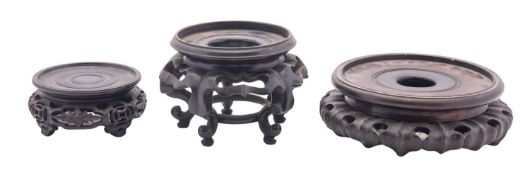 A group of three Chinese carved and pierced wood stands, late 19th/20th century,