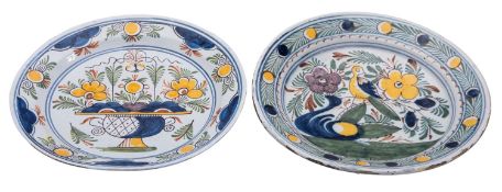 Two Dutch delft chargers both with polychrome decoration one with a jardiniere of blooms the