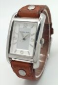 A MICHAEL KORS, STEEL, BROWN LEATHER STRAP WATCH. ORIGINAL STRAP AND BUCKLE. IN FULL WORKING