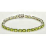 A Stylish Sterling Silver and Peridot Set Tennis Bracelet-19.5cm Length. Set with Thirty 6 x 4mm