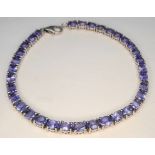 A Stylish Sterling Silver and Tanzanite Set Tennis Bracelet-19.5cm Length. Set with Thirty-Four 5