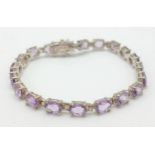 A Pretty Sterling Silver and Amethyst Set Tennis Bracelet. 19cm Length. Set with Twenty 6 x 5mm Oval