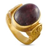 An 18K Yellow Gold 24.70ct Ruby Ring. The 18K Yellow Gold setting features scrollwork and a 24.70-