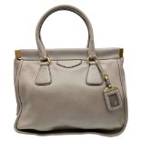 A Prada Taupe Leather Tote Bag. Taupe leather exterior with gold-tone hardware, double rolled