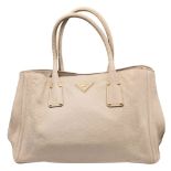 A Prada Vitello Daino Leather Tote Bag. Beige pebbled leather exterior with gold-tone hardware,