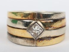 An unmarked substantial yellow and white metal single stone diamond four and ring, probably 18ct