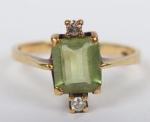 An 18ct gold diamond and peridot ring, peridot flanked by two diamonds, peridot stone 7mm, 3.06g