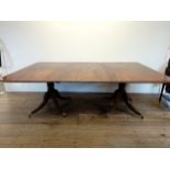 A Regency mahogany twin pillar dining table, inset an extra leaf, on baluster turned columns with
