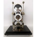 A modern single fusee grasshopper skeleton clock, incorporating a phase of the moon, on an