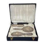 A three-piece silver backed brush and mirror set, Birmingham, 1926, embossed overall, cased (3)