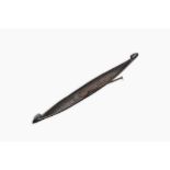 A large Indian wooden Kerala snake canoe with a curled stem and stern with accompanying paddle, 20th