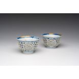 A pair of Chinese blue and white reticulated double walled cups with floral design and kintsugi repa