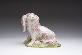 A polychrome Brussels faience model of a seated dog, 18th C.