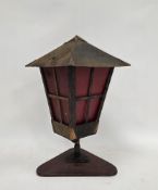 Mid-century metal lantern table lamp with copper mounts and opaque textured red glass panels, on a