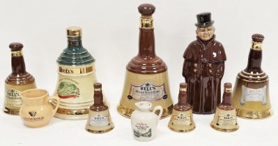 Collection of Bell's Whisky decanters in sizes, including three miniatures, a pottery coachman