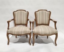 Pair of French open elbow chairs in the Louis XV style, having pink, green and cream upholstered