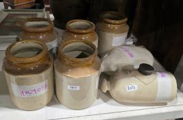 Five stoneware storage jars of cylindrical form and two early 20th century stoneware hot water