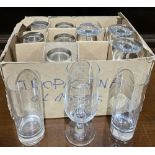 Collection of branded drinking glasses including Pilsner Urquell lager glasses, Smirnoff tumblers,