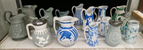 Collection of Victorian pottery relief-moulded jugs including blue and white Parian examples by