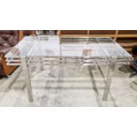 Contemporary dining table by Andrew Martin, the glass top on a chrome base with square legs, 74cm