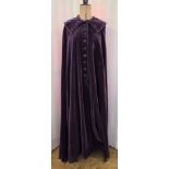 An Edwardian full-length velvet cape, in purple with a wired up-standing collar, velvet button