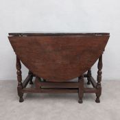 An 18th century oak drop leaf dining table on turned and stretchered gate-leg supports. H.70 W.95