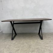 A contemporary dining table or writing desk with stained oak lozenge top raised on black metal x-