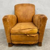 An early 20th century tan leather upholstered Art Deco club armchair with shaped back and arms