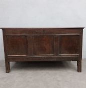 An 18th century panelled oak coffer with hinged top on stile supports. H.72 W.129 D.54cm